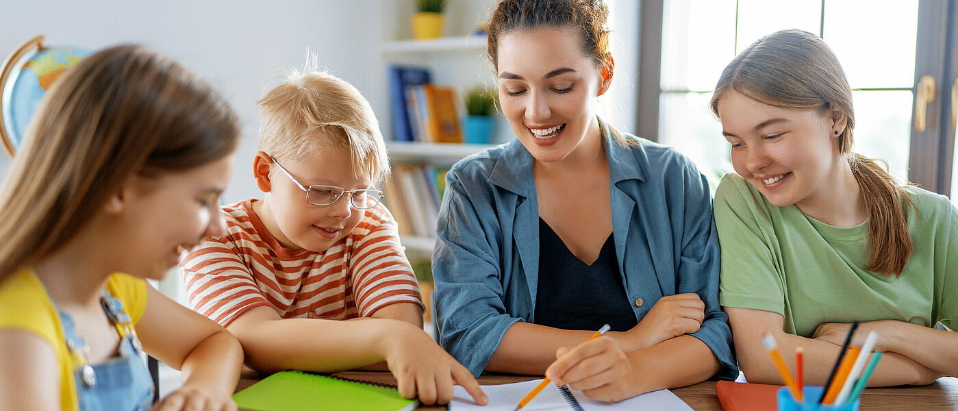 Lehrkraft schreibt Schülern etwas auf
