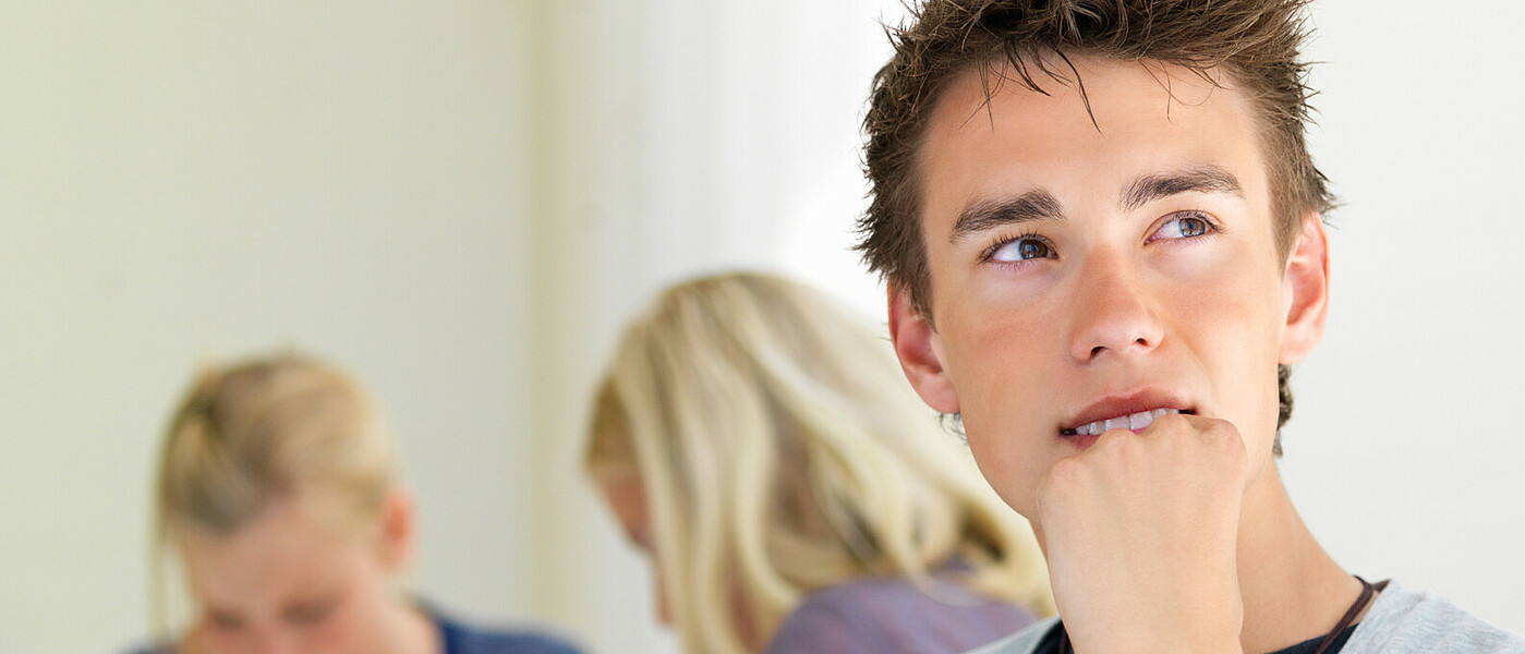 Schüler vor Laptop © I-Stock Oberstufenschüler sitzt beim Tisch vor dem Laptop, denkt nach.