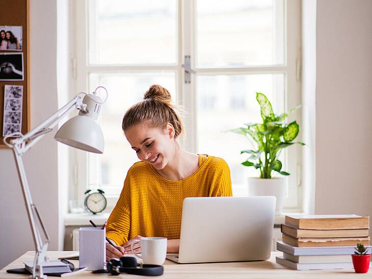 Eine Schülerin lernt beim Schreibtisch, auf dem eine Schreibtischlampe an idealer Position steht.