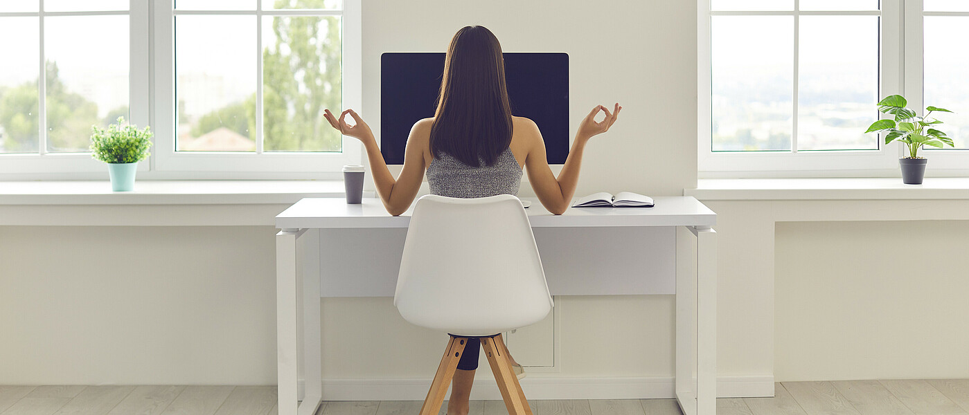 Pressegespräch School Life Balance  Schülerin von hinten sichtbar am Schreibtisch sitzend mit Yoga-Armstellung.