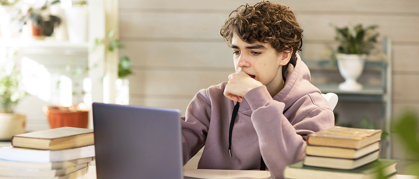 Jugendlicher mit Laptop beim Lernen mit Online Lernplattform