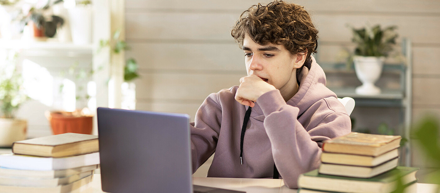 Jugendlicher mit Laptop beim Lernen mit Online Lernplattform