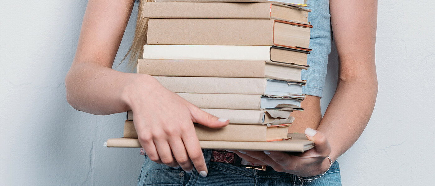 Oberstufenschülerin mit Bücherstapel © I-Stock Oberstufenschülerin mit Bücherstapel in den Händen