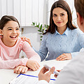 Mutter und Tochter beim Elternsprechtag im Gespräch mit einem Lehrer