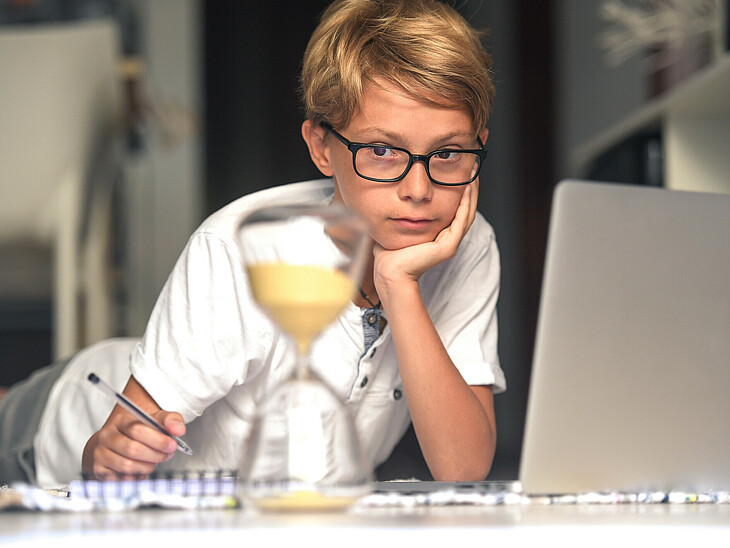 Schüler beim Lernen mit Sanduhr