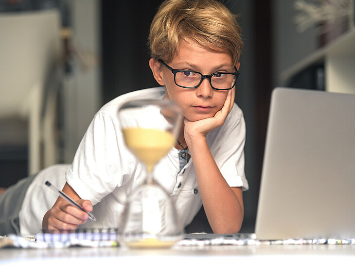 Schüler beim Lernen mit Sanduhr