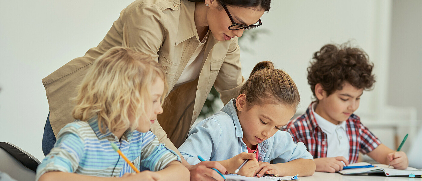 eine Gruppe von Kindern beim Lernen mit Lehrerin