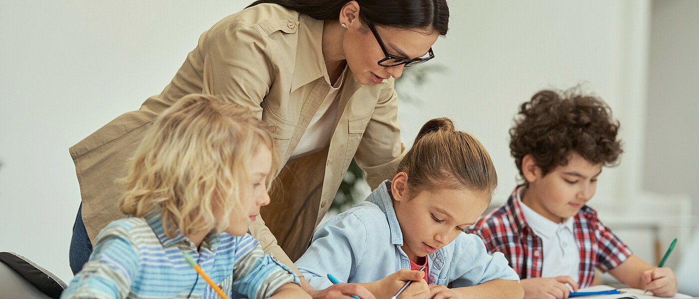 eine Gruppe von Kindern beim Lernen mit Lehrerin