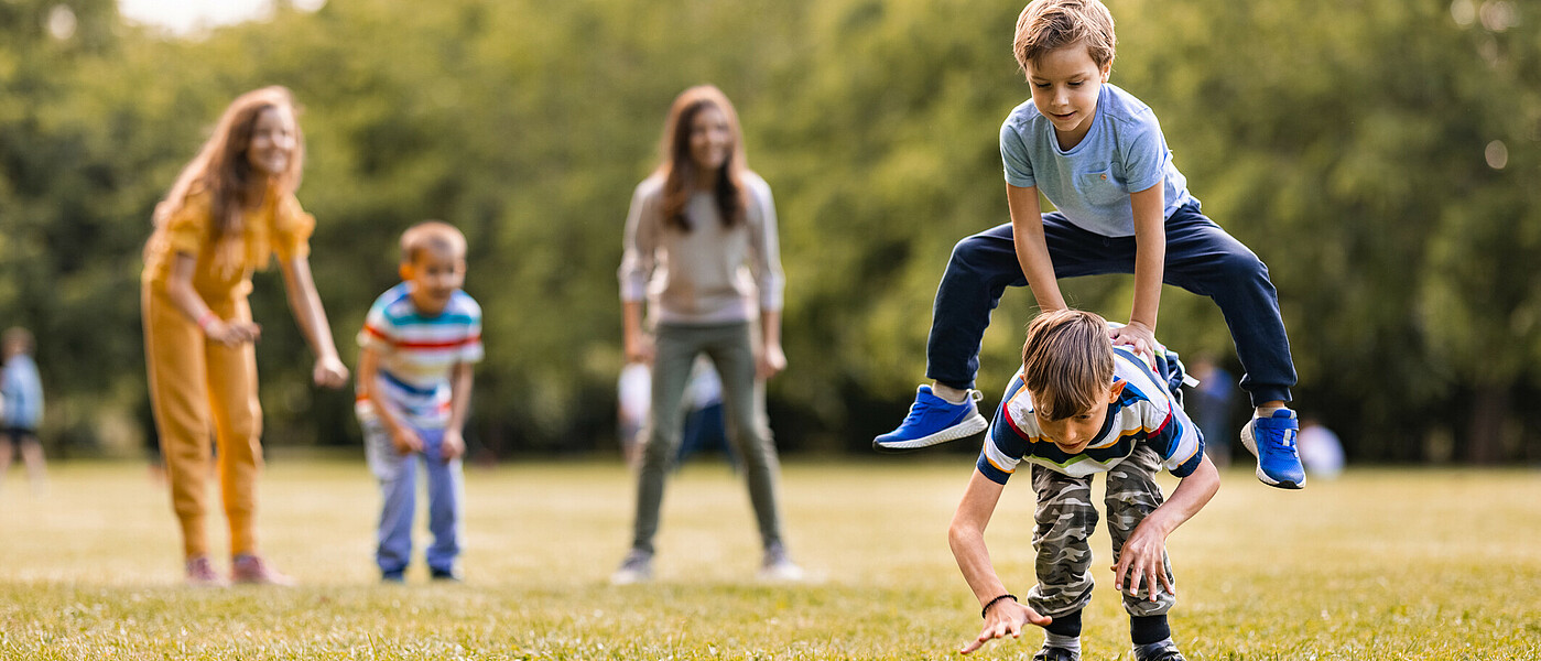 Bewegung zum Quadrat  Schüler beim Spielen auf einer Wiese