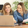 Zwei Schülerinnen sitzen vor dem Laptop