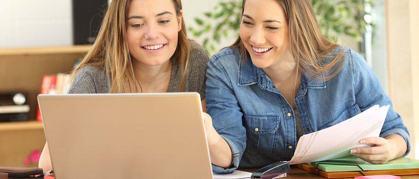 Zwei Schülerinnen sitzen vor dem Laptop