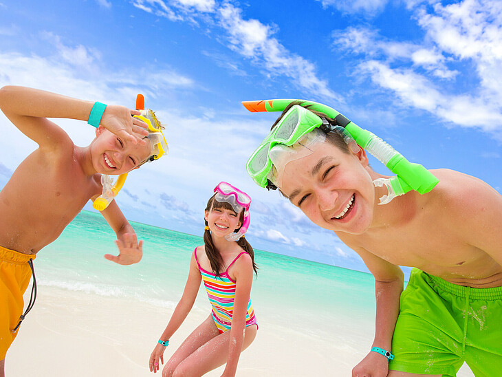 Drei SchülerInnen am Strand genießen die Ferienzeit. Trotz Nachprüfung darf der Urlaub nicht zu kurz kommen.