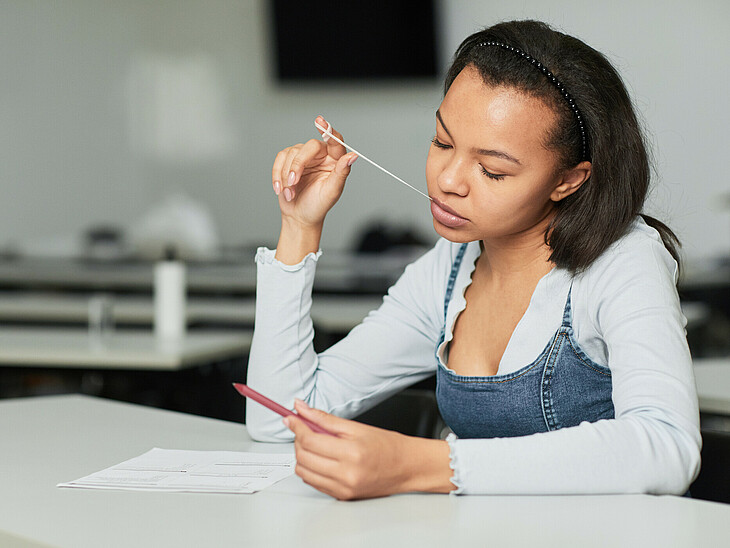Eine Schülerin kaut beim lernen Kaugummi. So kann sie sich gut konzentrieren.