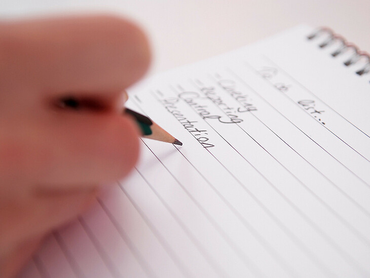 Ein Schüler notiert Fehler untereinander auf einer Liste