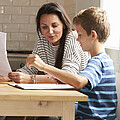 Eltern mit zwei Kindern sitzen beim Tisch und lernen