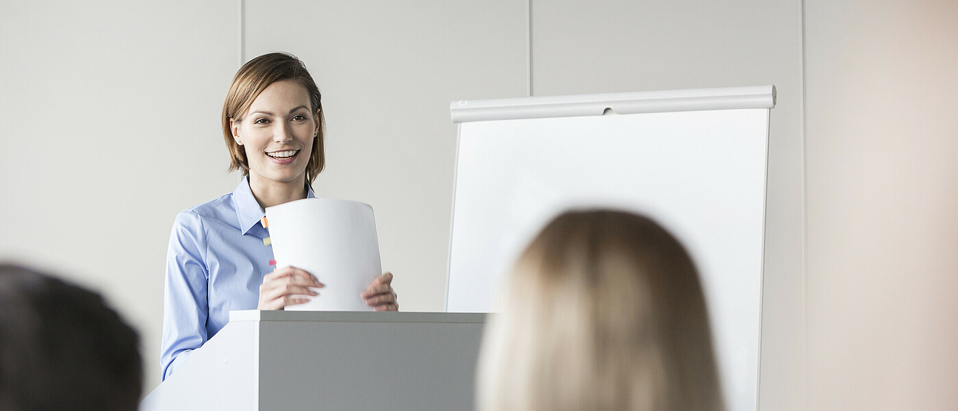 Eine Maturantin bei der Präsentation ihrer VWA am Rednerpult stehend