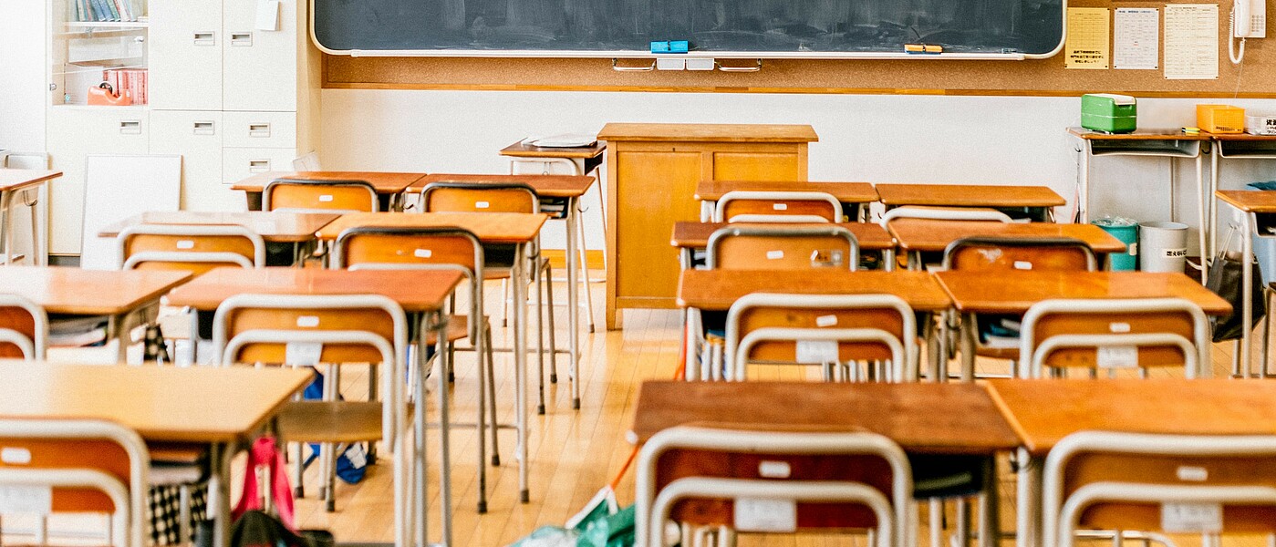 Klassenzimmer mit Bankreihen und Tafel