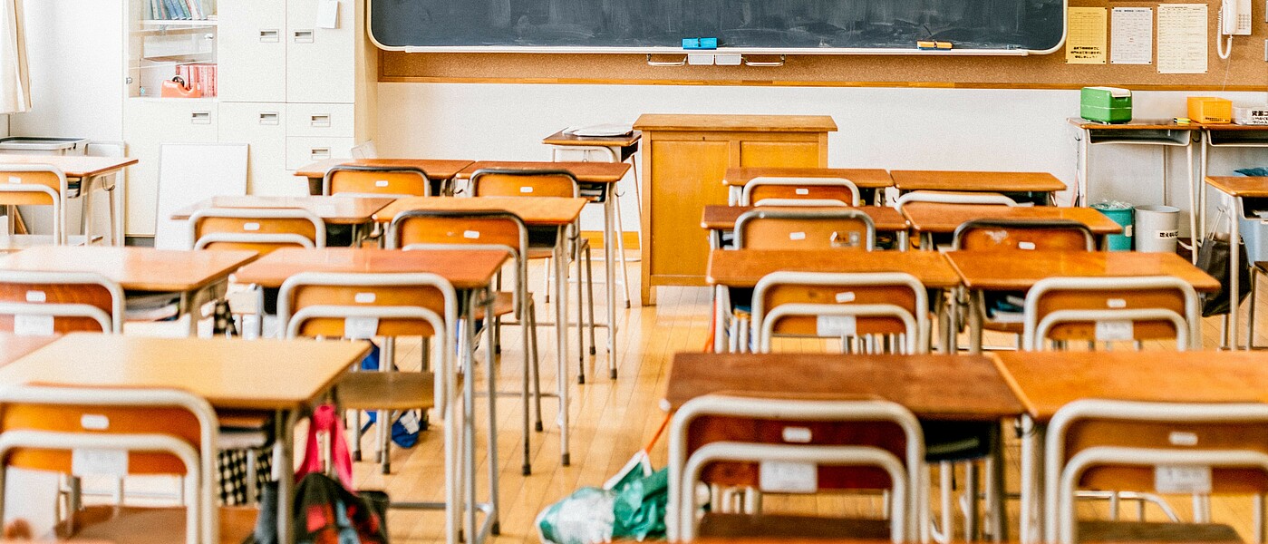 Klassenzimmer mit Bankreihen und Tafel