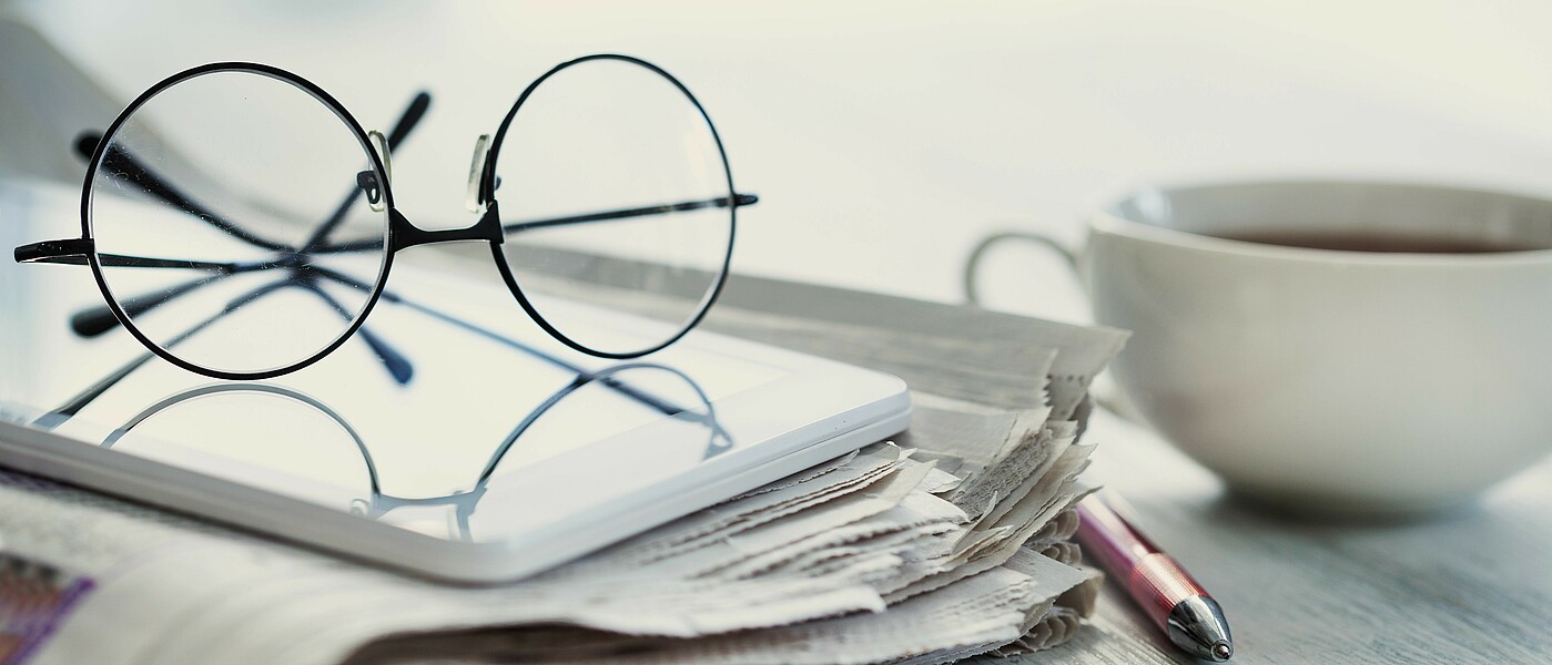 Zeitung, Kaffee, Brille © I-Stock Zeitung, Kaffee und Brille auf einem Tisch