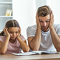Vater und Tochter ratlos beim Lernen