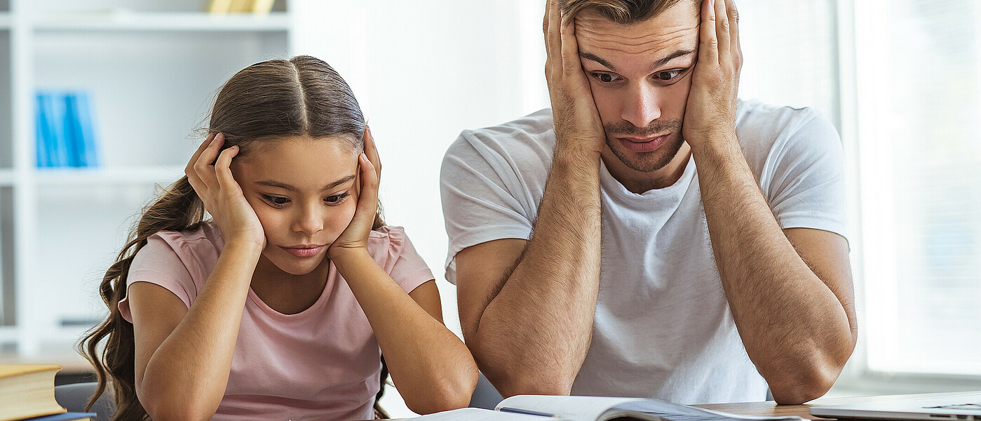 Vater und Tochter ratlos beim Lernen