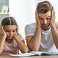 Vater und Tochter ratlos beim Lernen
